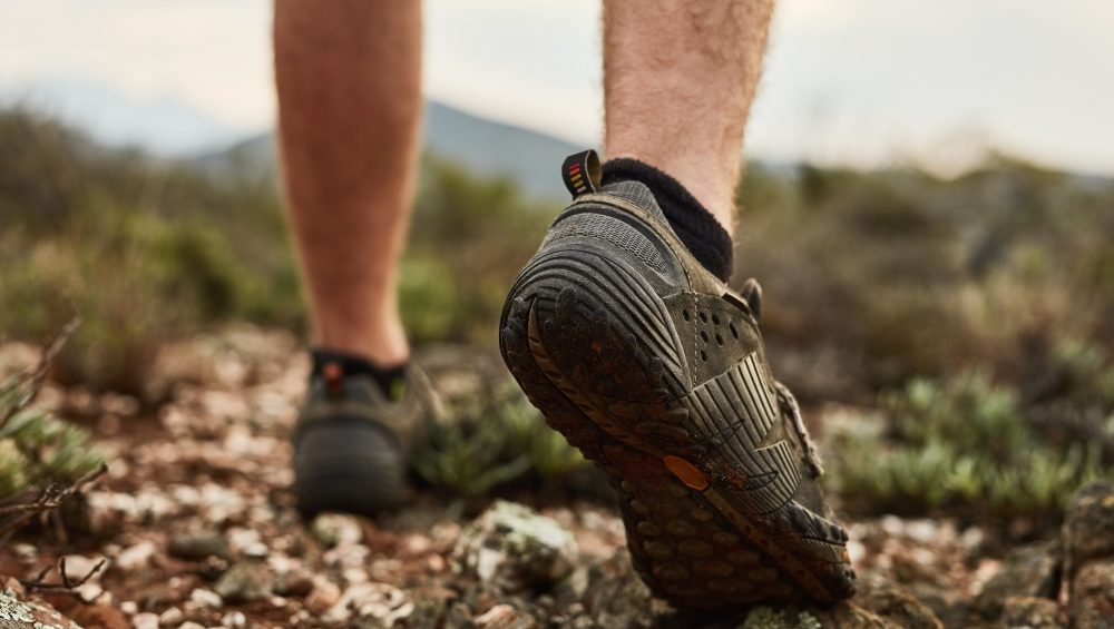 Cropped shot of an unidentifiable young hikers feet walking on a mountain trail