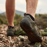 Cropped shot of an unidentifiable young hikers feet walking on a mountain trail